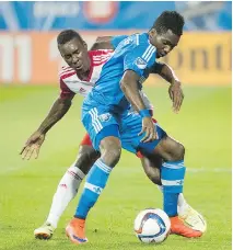  ?? GRAHAM HUGHES/THE CANADIAN PRESS ?? Impact’s Ambroise Oyongo, right, challenges the New York Red Bulls’ Lloyd Sam during a matchup in Montreal on Wednesday night. The teams played to a 1-1 draw.