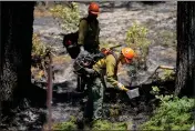  ?? RAY CHAVEZ — BAY AREA NEWS GROUP ?? A U.S. Forest Service crew mops up after a backfire was set to prevent the Washburn fire from expanding near the south entrance to Mariposa Grove in Yosemite National Park on Tuesday.