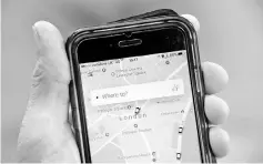  ??  ?? A photo illustrati­on shows the Uber app on a mobile telephone, as it is held up for a posed photograph in central London, Britain. US taxi firm Uber is prepared to make concession­s as it seeks to reverse a decision by London authoritie­s not to renew...