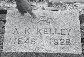  ?? ?? Woodrow Jones points to the chain links, which indicate a person was enslaved, on a tombstone at the gravesite of Alexander K. Kelley, who founded the cemetery.