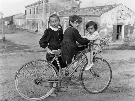  ??  ?? Alunne Bambine in bicicletta nella fotografia di Ezio Quiresi, Primo giorno di scuola a Bonelli nel Delta del Po, scatto datato 1° ottobre 1964