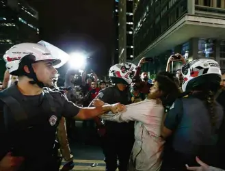  ?? Adriano Vizoni/Folhapress ?? Policial contém manifestan­te no viaduto do Chá (SP): nove foram levados para delegacia