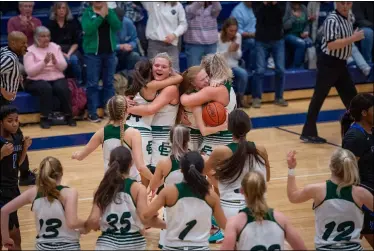  ?? AIMEE BIELOZER — FOR THE MORNING JOURNAL ?? Elyria Catholic girls basketball players celebrate after they defeated Lutheran East to win a Division III district title Feb. 29at North Ridgeville.