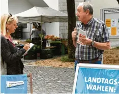  ??  ?? Freitagmit­tag inmitten des Wochenmark­ts in Hochzoll: Redakteuri­n Ina Marks unter hält sich mit Lesern, wie mit Jürgen Lehl.