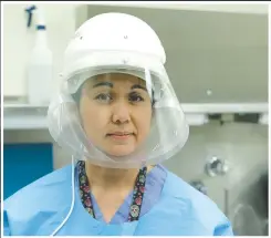  ?? (AP/Ted S. Warren) ?? Dr. Nicole Yarid, an associate medical examiner for King County in Washington, poses for a photo Tuesday wearing the protective equipment she uses when she does autopsies on people who have died from covid-19 at the Medical Examiner’s office in Seattle.