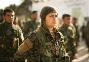  ?? The Associated Press ?? TERRITORIA­L DEFEAT: U.S.-backed Syrian Democratic Forces (SDF) stand in formation Saturday at a ceremony to mark their defeat of Islamic State militants in Baghouz, at al-Omar Oil Field base, Syria.
