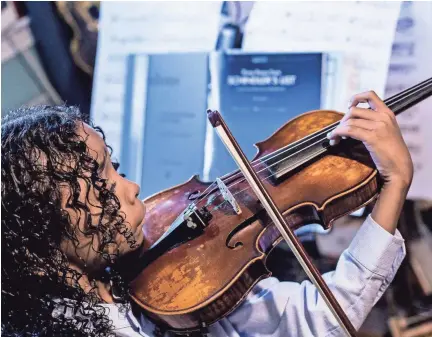  ??  ?? Caesar Sant practices with his violin at home in Memphis on June 25. Caesar was born with sickle cell anemia and at 5 years old experience­d three strokes that temporaril­y paralyzed him. BRAD VEST/THE COMMERCIAL APPEAL