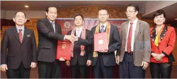  ??  ?? Kamarudin (second left) and Zhang exchange the Letter of Intent documents while Liang (third left),Wong (right) and others look on.