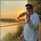  ?? (Arkansas Democrat-Gazette/Bryan Hendricks) ?? Joe Volpe of Little Rock shows off a largemouth bass amid the splendor of an October sunset.