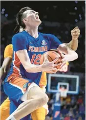  ?? ALAN YOUNGBLOOD/AP ?? Florida forward Colin Castleton gets fouled by Tennessee forward Jonas Aidoo during the second half of Wednesday’s game in Gainesvill­e.