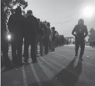  ?? MARIO TAMA / GETTY IMAGES FILES ?? Migrants wait in line to receive dinner outside a temporary shelter set up for members of the ‘migrant caravan’ on Nov. 27 in Tijuana, Mexico. Around 6,000 migrants from Central America have arrived in the city.