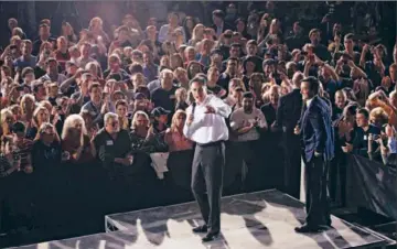  ?? Charles Dharapak Associated Press ?? MITT ROMNEY, center, campaigns with Puerto Rico Gov. Luis Fortuño in January in Orlando, Fla. Romney is visiting Puerto Rico after Rick Santorum — but Latinos seem to be wary of both leading GOP candidates.