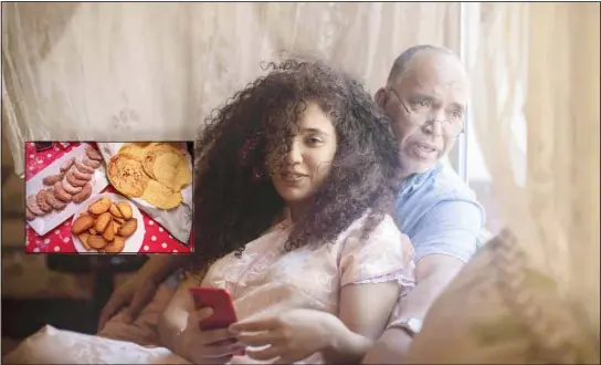  ??  ?? Yousra Sandabad and her father Moustafa share a moment as they spend the first day of Eid in lockdown due to the coronaviru­s pandemic, in Casablanca, Morocco, Sunday, May 24, 2020.
Inset: Moroccan sweets are displayed on a table inside the home of Ghita Naoui as she and her relatives spend Eid in lockdown. (AP)