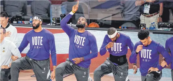  ?? FOTO: MARK J. TERRILL/DPA ?? Die Botschaft ist deutlich: Spieler der Los Angeles Lakers um LeBron James (Mitte) senden einen klaren Appell an die Bevölkerun­g – „Vote“(wählt).