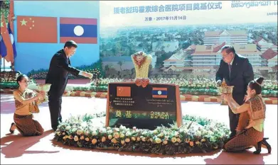  ?? MA ZHANCHENG / XINHUA ?? President Xi Jinping and Laotian President Bounnhang Vorachith place flowers during a ceremony on Tuesday marking the start of work on a hospital expansion in Vientiane, Laos, involving money and equipment from China.
