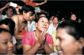  ?? Hku n Lat / Associated Press ?? Supporters of opposition leader Aung San Su Kyi’s National League for Democracy Party watch returns Sunday in Mandalay, Myanmar.