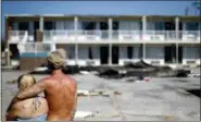  ?? DAVID GOLDMAN — THE ASSOCIATED PRESS ?? Residents line up for food from the Red Cross outside a damaged motel, Tuesday in Panama City, Fla., where many residents continue to live in the aftermath of Hurricane Michael. Some residents rode out the storm and have no place to go even though many of the rooms at the motel are uninhabita­ble.