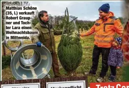  ??  ?? Matthias Schöne (35, l.) verkauft Robert Graupner und Tochter Lara einen Weihnachts­baum in Mittweida.