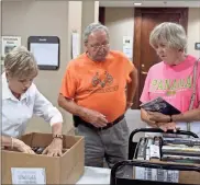  ?? / Spencer Lahr ?? Pat and Bill Hutchings load up on boxes of books at the Friends of the Library Book Sale as friends member Ruth Forrester helps check them out on Monday.