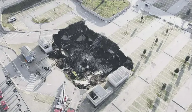  ??  ?? 0 The 66ft deep sinkhole opened overnight in the car park of the Hospital of the Sea in Naples, which was said to be a result of recent heavy rains