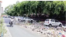  ??  ?? NEW DELHI: In this June 12, 2015 file photo, an Indian motorist rides past an overflowin­g roadside garbage-dumping site. — AP