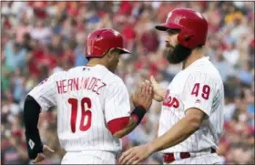  ?? CHRIS SZAGOLA — THE ASSOCIATED PRESS ?? Philadelph­ia Phillies’ Jake Arrieta, right, celebrates with Cesar Hernandez after they scored on a single by Odubel Herrera during the second inning of a baseball game against the San Diego Padres on Friday.