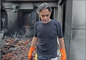  ?? AP PHOTO ?? Girogos Handrinos stands outside his burned house in Mati, east of Athens, Thursday.