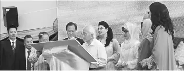  ??  ?? Taib signs the plaque to mark the opening of the Pibakis building in Miri.