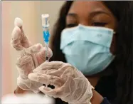  ?? AP PHOTO BY DAMIAN DOVARGANES ?? In this Thursday, March 11 file photo, a health worker loads syringes with the vaccine on the first day of the Johnson & Johnson vaccine being made available to residents at the Baldwin Hills Crenshaw Plaza in Los Angeles. California officials say much of the state will be able to reopen next week to indoor activities as coronaviru­s case rates remain low. At the same time, more than 4 million residents with certain disabiliti­es or health concerns become eligible for a vaccine.