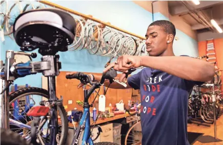  ?? ANGELA PETERSON / MILWAUKEE JOURNAL SENTINEL ?? Jacobi Wheeler works on the brakes of a bike at DreamBikes on North King Drive. DreamBikes hires neighborho­od kids and trains them to fix donated bikes, which are sold at affordable prices to kids in the community. Jacobi's brother was murdered last summer. DreamBikes is like a second home.