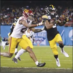  ?? Associated Press ?? TOUCHDOWN — Iowa wide receiver Ihmir Smith-Marsette, right, scores a touchdown ahead of Southern California safety Isaiah Pola-Mao (21) during the first half of the Holiday Bowl game on Friday in San Diego. Smith-Marsette scored three touchdowns in the Hawkeyes’ 49-24 victory.