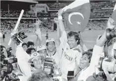  ??  ?? BLAST FROM THE PAST: Pakistan’s cricket captain Imran Khan, waving a Pakistan flag, is cheered by teammates after Pakistan defeated England in the World Cup Cricket final.