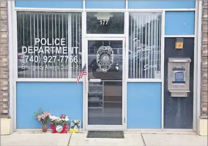  ?? [TOM DODGE/DISPATCH] ?? Flowers were left outside the Kirkersvil­le Police Department on Friday in memory of Police Chief Steven Eric DiSario, who was killed in the shootings at the Pine Kirk Care Center.