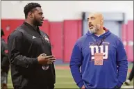  ?? Chris Seward / Associated Press ?? Tackle Ikem Ekwonu, left, talks with Bobby Johnson of the Giants during North Carolina State Pro Day on March 29 in Raleigh, N.C.