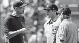  ?? JIM MCISAAC/GETTY ?? Yankees manager Aaron Boone argues with umpires Ben May, center, and Tom Hallion.