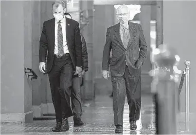  ?? TASOS KATOPODIS/GETTY ?? Senate Majority Leader Mitch McConnell, R-Ky., right, walks to the Senate floor last week at the U.S. Capitol. .