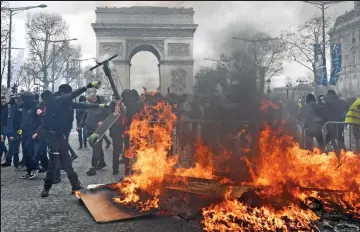  ??  ?? Paris is burning: Many protesters want Macron, above, to quit