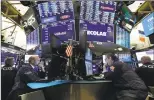  ?? Richard Drew / Associated Press ?? James Denaro, left center, and Gregg Maloney, right center, on the floor of the New York Stock Exchange on Oct. 21.