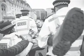  ?? — Gambar Reuters ?? TANGKAP: Pegawai polis menangkap penunjuk perasaan semasa protes ‘Extinction Rebellion’ di London, Britain kelmarin.