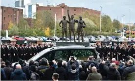  ?? Photograph: Rui Vieira/AP ?? The hearse carrying Bobby Charlton passes by the statue featuring him alongside George Best and Denis Law outside Old Trafford on its way to the funeral service.