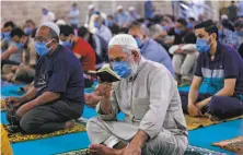  ?? Mahmud Hams / AFP / Getty Images ?? Palestinia­ns attend Friday prayers at alOmari mosque in Gaza City. The congested region recorded its first COVID19 death.