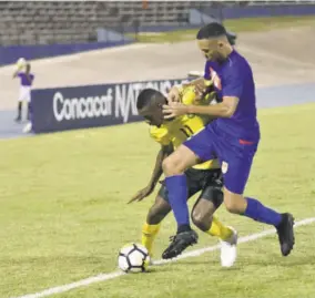  ??  ?? Jamaica’s scorer Cory Burke (left) and Colby Seymour of Cayman Islands challenge for possession during their Concacaf Nations League game inside the National Stadium on Sunday, Setpetmebr 9, 2018. Jamaica won 4-0.