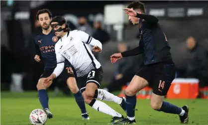  ??  ?? Yan Dhanda in action for Swansea against Manchester City. He was racially abused online after the game. Photograph: Michael Steele/ Getty Images