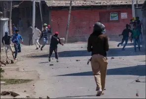  ?? AP/DAR YASIN ?? Kashmiri protesters throw stones and bricks at an Indian paramilita­ry soldier during a demonstrat­ion Sunday at Srinagar in Indian-controlled Kashmir.