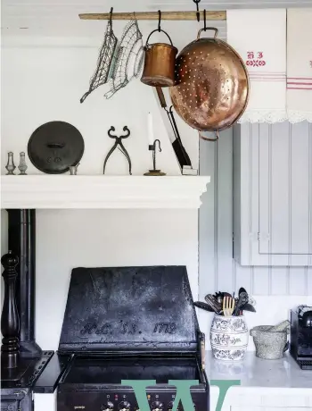  ??  ?? RIGHT Antique hobo wire craft hangs on the drying rod (on which crisp bread was dried in the old days, when every household baked their own bread). A cast-iron fireplace screen is used as a splashback to the electric stove.