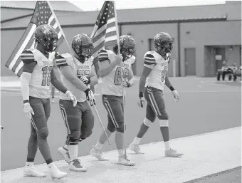  ??  ?? Edmond Santa Fe enters the field with flags for a military appreciati­on ceremony before a game against Westmoore on Oct. 3 at Moore Stadium. [SARAH PHIPPS/ THE OKLAHOMAN]