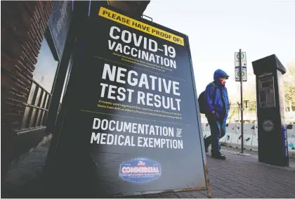  ?? DAVID BLOOM ?? A pedestrian walks past a sign advertisin­g the COVID-19 restrictio­ns that are in place at the Commercial Hotel-blues On Whyte Pub on Thursday. The province has announced plans to provide supports, incentives and legal measures to businesses enforcing COVID-19 vaccine rules.