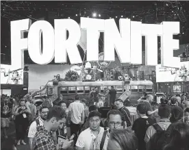  ?? CHRISTIAN PETERSEN/GETTY IMAGES ?? Game enthusiast­s and industry personnel visit the “Fortnite” exhibit during the Electronic Entertainm­ent Expo E3 at the Los Angeles Convention Center on June 12.