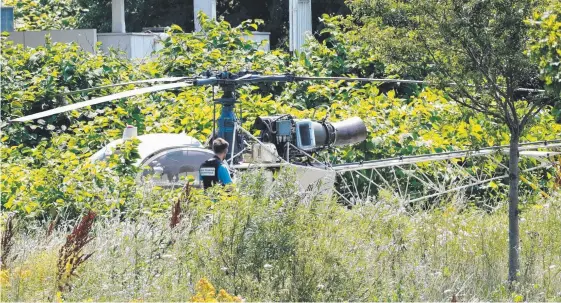  ?? Picture: AFP ?? Police inspect the helicopter used by bank robber Redoine Faid (inset, left) during his escape from the Sud-Francilien prison (inset, right) near Paris on the weekend.