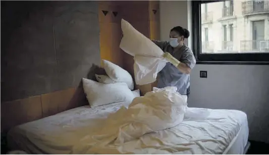  ?? David Zorrakino / Europa Press ?? Una cambrera de pisos canvia els llençols d’un llit en una habitació d’hotel.